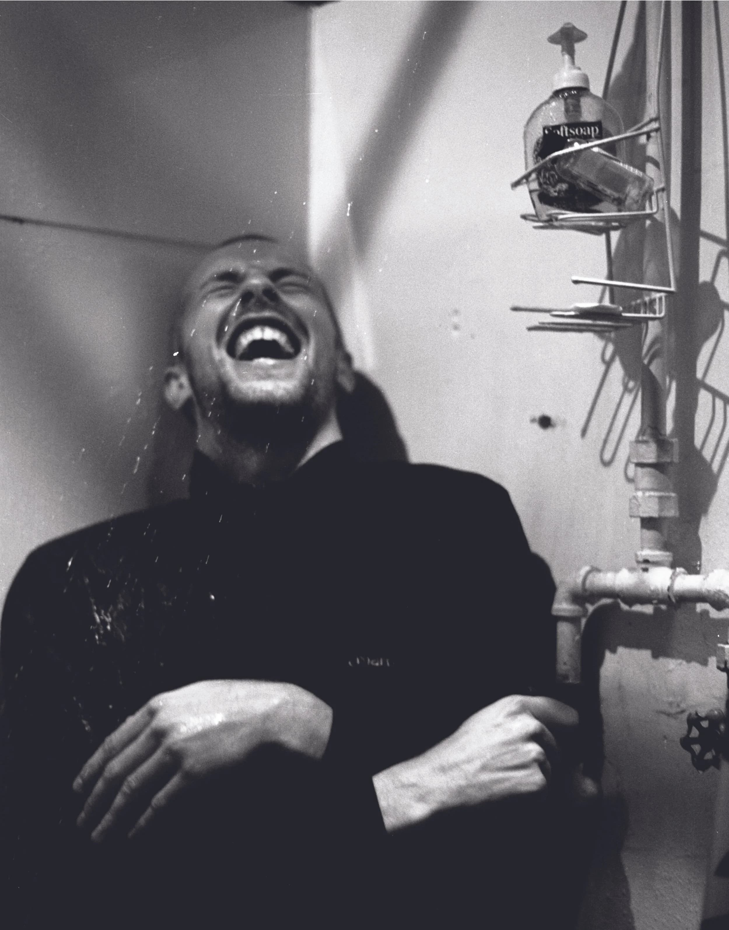 Black and white photograph of Chris Martin laughing
